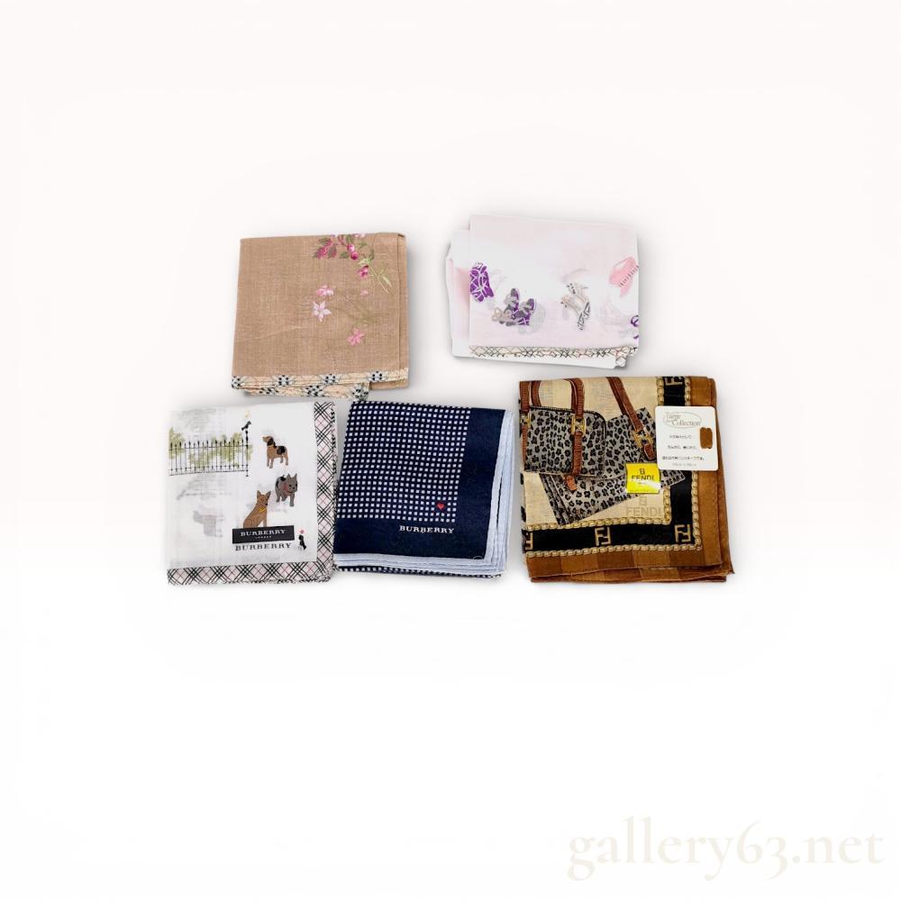 Description
An assortment of five designer handkerchiefs featuring examples from Fendi and Burberry. The collection includes a Fendi leopard and handbag motif design, a Burberry London dog park illustration, a navy Burberry micro-check with heart detail, and two additional floral and fashion-themed pieces. Each item is constructed from cotton and features printed or embroidered decorative elements. Notable markings include a Fendi Large Collection tag and a Burberry London Japanese license sticker.
Fendi: 58cm x 58cm
Burberry Dog Park: 50cm x 50cm
Burberry Micro-check: 48cm x 48cm.