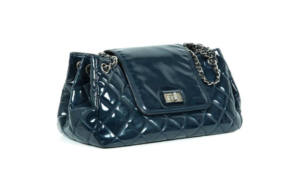 CHANEL

Sac 30 cm en cuir vernis matelassé bleu marine, fermeture en acier chromé signé sur rabat, double demi-anse bandoulière chaine métal chromé entrelacé de cuir, poche intéerieur. Hologramme. (Traces sur le vernis)