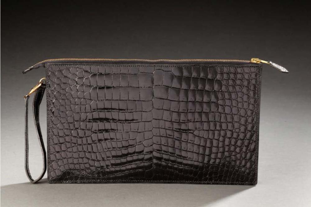 HERMES

Pochette zippée compartimentée en crocodile noir verni attache poignet. 15 X 25,5cm env. Bon état