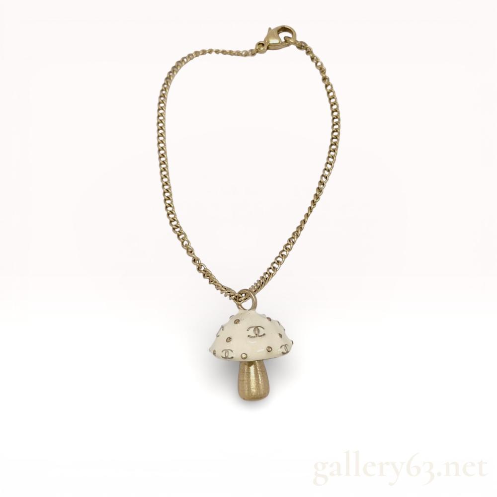 Description
NOTE: WE ALSO HAVE THE MATCHING NECKLACE IN THIS AUCTION! Chanel 03S Mushroom Charm Bracelet


Chanel mushroom charm bracelet from the Spring 2003 collection, featuring a sculptural mushroom-form charm suspended from a gold-tone chain. Charm having an ivory-toned cap set with repeating interlocking CC motifs and small stud accents, paired with a brushed gold-tone stem. Bracelet finished with a lobster clasp closure, presenting a whimsical yet iconic example of early 2000s Chanel costume jewelry design.