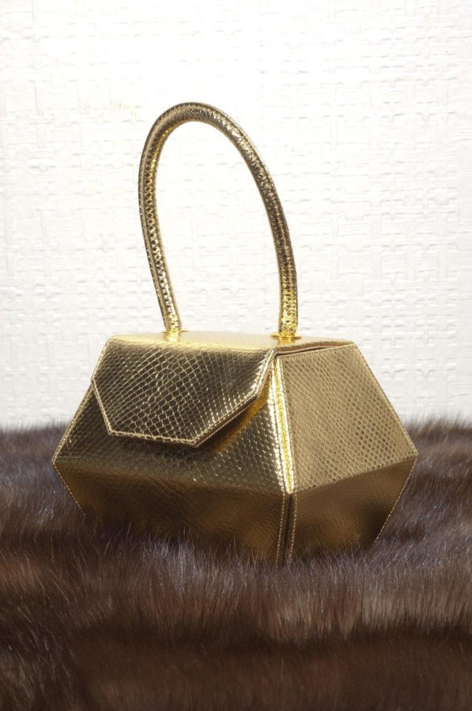 Renaud PELLEGRINO

Sac boîte à côtés facettés en cuir métallisé or imprimé façon réptile. Excellent état.