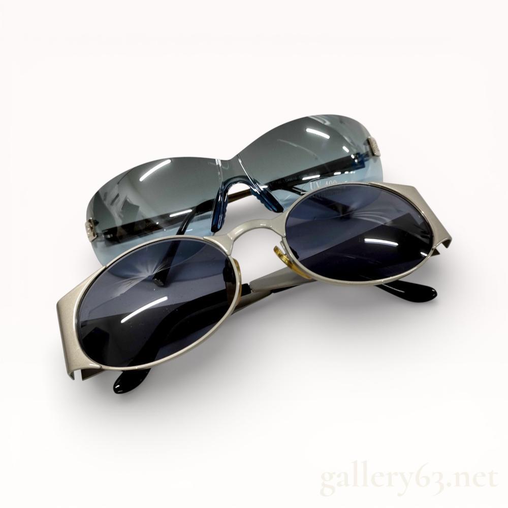 Description
Authentic set of two Chanel sunglasses presented together. One pair featuring a rimless shield-style design with gradient lenses and minimal metal fittings. Second pair featuring oval lenses set within a light metallic frame with contrasting dark lenses. Both pairs fitted with adjustable nose pads and curved temples. Set accompanied by a Chanel branded storage box. Offered together as a single lot.