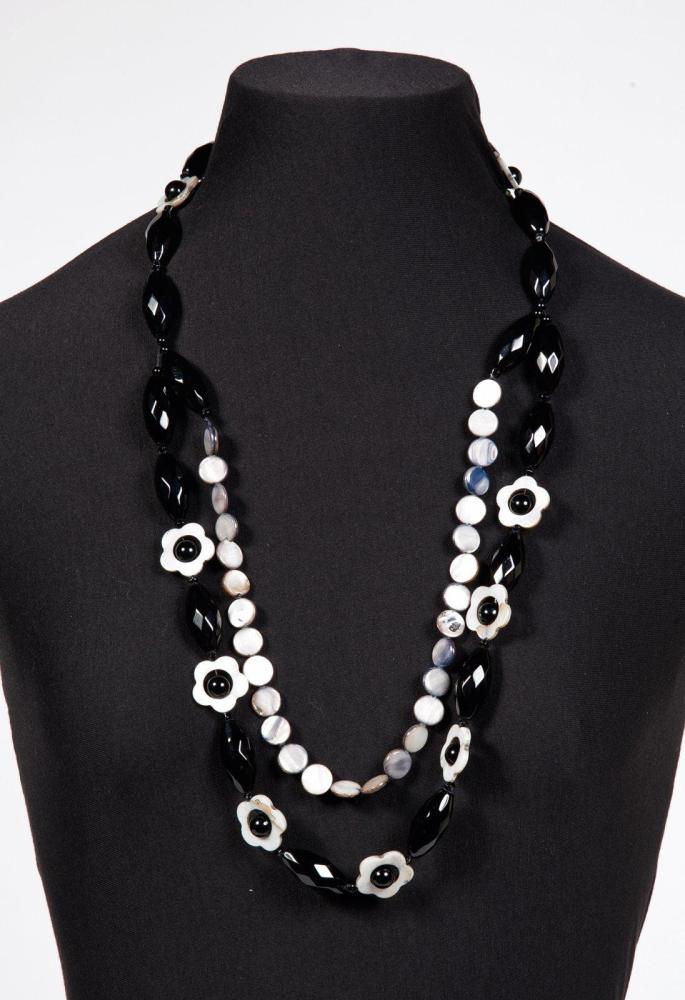 CHANEL

Collier en nacre et galalithe noire composé sur un double rang de fleurettes et de perles facettées retenues par des pastilles de nacre. Non signé
