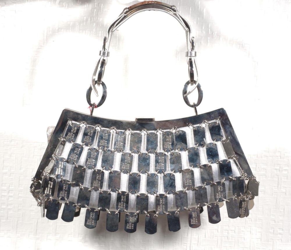 Christian DIOR par John GALLIANO

Sac en toile métallisée argent recouverte de plaques d’inspiration militaire en métal chromé, certaines gravées, fermoir à l’identique, poignée cuir ornée d’une plaque gravée Dior