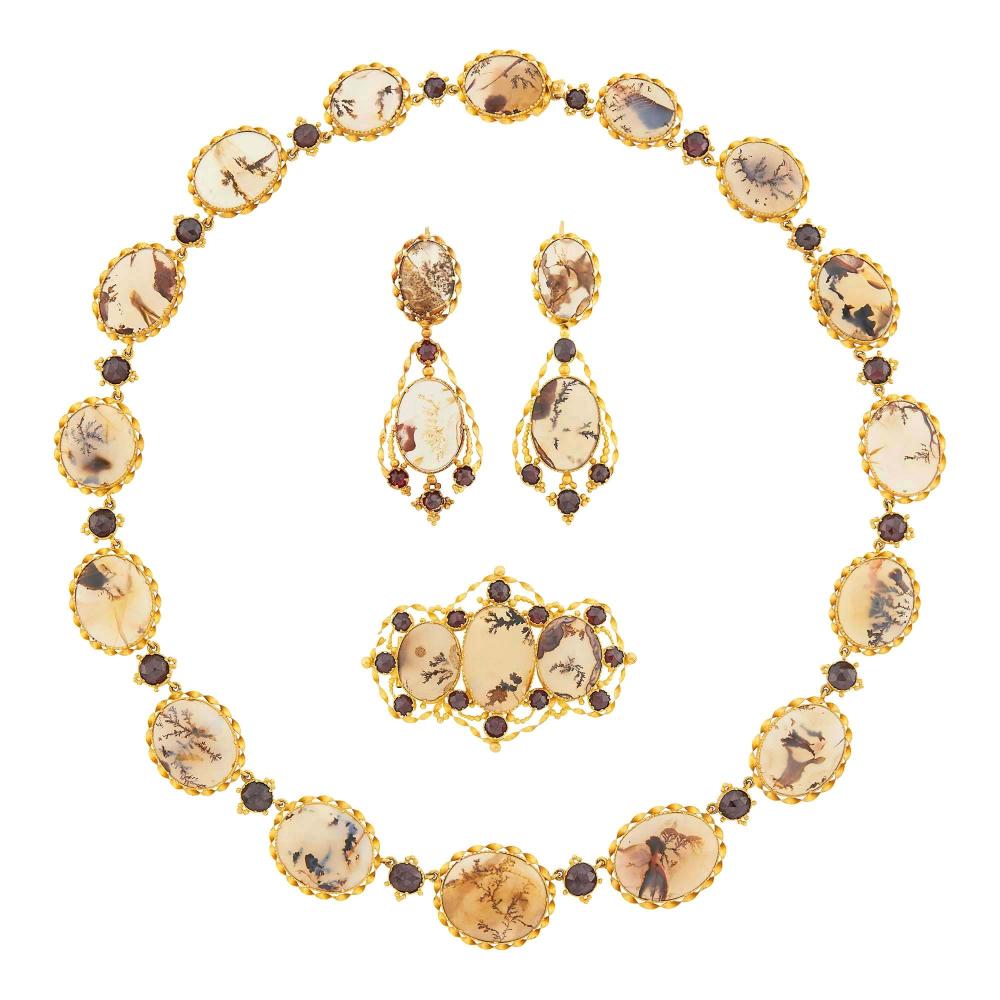 Property from a Prominent Downtown Charleston EstateIncluding a necklace, pendant-earrings and brooch, oval moss agate, round garnets, circa 1870. Length 15 1/4 inches. With original fitted box.

Agate: cream to white colorless transparent to translucent, visible moss-like inclusions, few surface-reaching, very good polish, some slightly uneven, mid to shallow cabochons.Brooch 1 7/8 x 1 1/4 inches.Pendant-earrings with hinged French backs that attach at top. 1 7/8 x 3/4 inches.Necklace width 3/4 to just over 1/2 inch.                            
Any condition statement is given as a courtesy to a client, is an opinion and should not be treated as a statement of fact and our Organization shall have no responsibility for any error or omission. Please contact the specialist department to request further information or additional images that may be available.