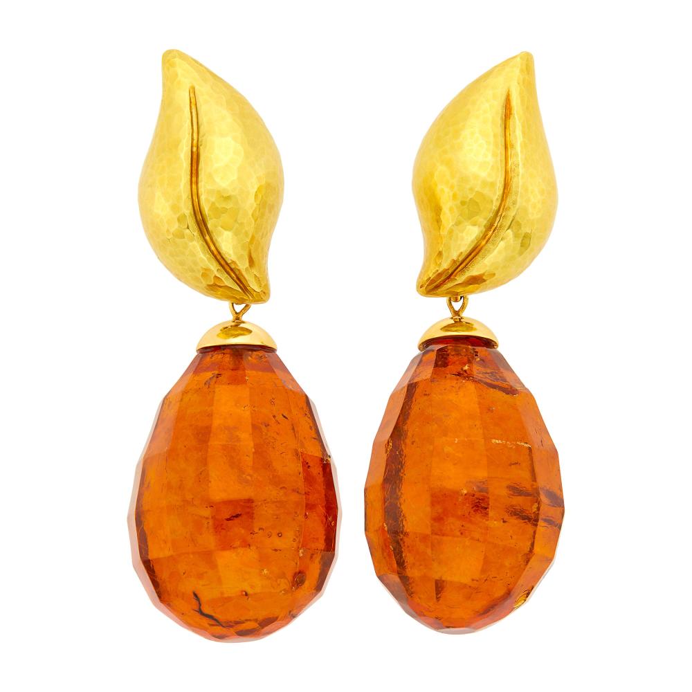 18 kt., 2 faceted drop-shaped amber ap. 35.0 x 26.0 x 24.0 mm., signed Tiffany & Co., Paloma Picasso, Italy, ’89’, pendants detachable, tops ap. 8.6 dwts.

Amber: deep orange, moderately included, some visible, several surface-reaching, chip towards side of lower tip, translucent.Clip-backs. Tops 1 1/4 x 3/4 inches. With pendants 2 7/8 x 1 inches.                            
Any condition statement is given as a courtesy to a client, is an opinion and should not be treated as a statement of fact and our Organization shall have no responsibility for any error or omission. Please contact the specialist department to request further information or additional images that may be available.
