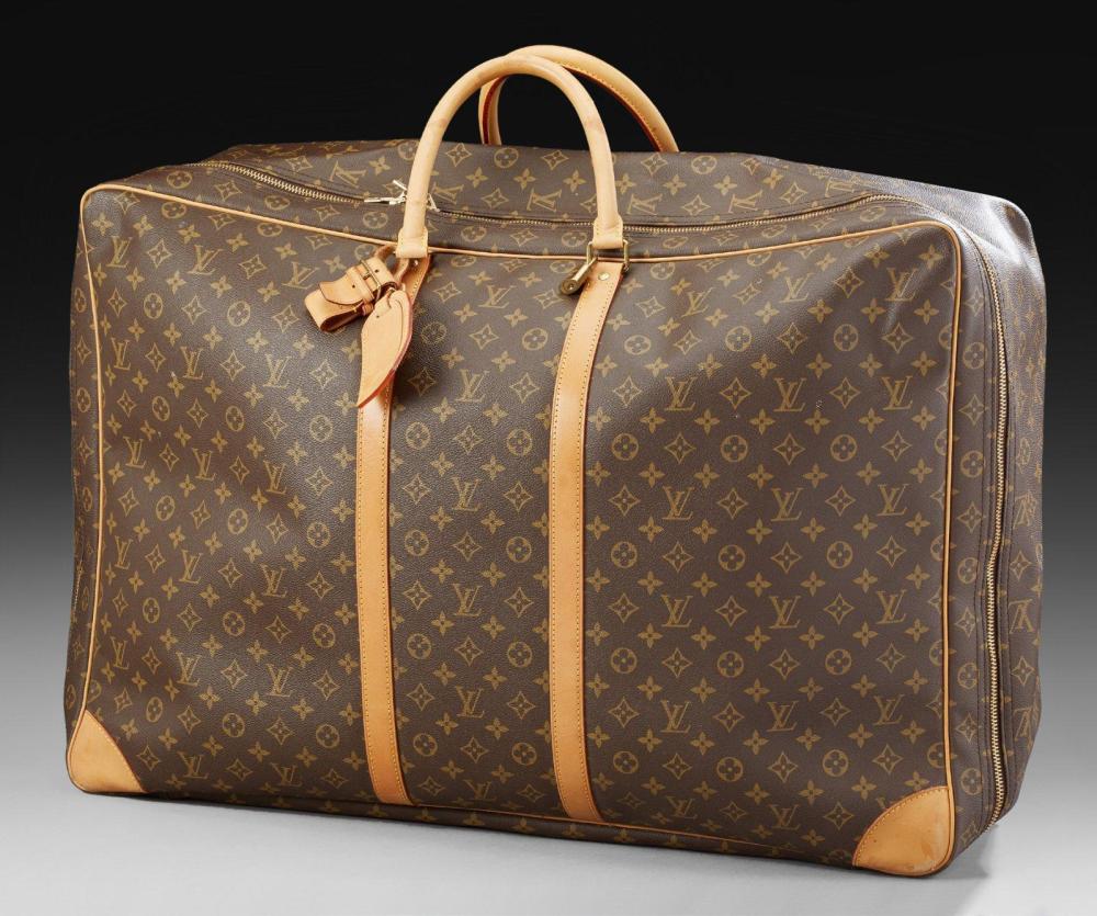 LOUIS VUITTON

Grande valise souple en toile Monogram, sangles, poignées et coins en cuir naturel. Poche intérieure sous le rabat. Numéroté clé Dim.: 49 x 70 x 19 cm. Petites usures aux coins mais très bel état général. Intérieur en parfait état