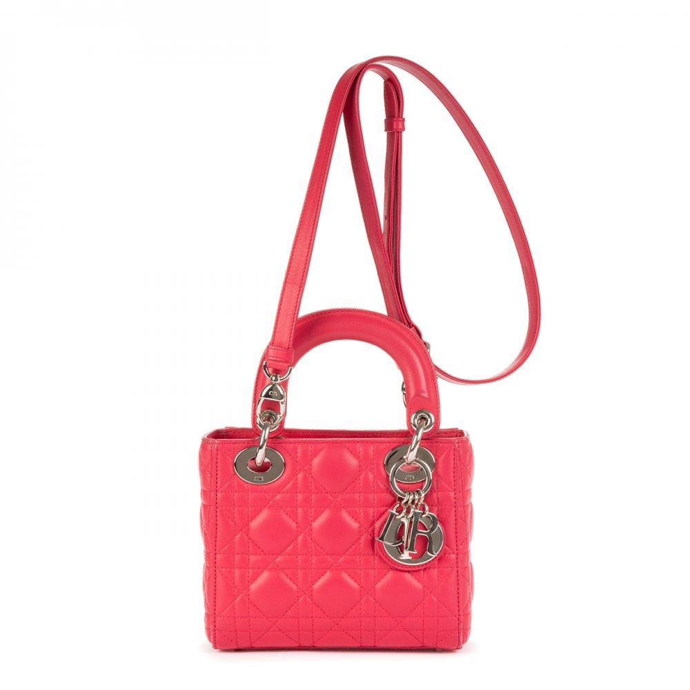 Description

DIOR
Mini Lady Dior bag.
Fuchsia pink leather, with iconic "cannage" stitching. Silver hardware. D.I.O.R. Charms. Double short top handle. Long removable shoulder strap. Zipper closure.
Includes removable handle and charm.
With interior numbering.
In perfect condition, hardly used.
Measurements: 17 x 14,5 x 6 cm.
The Lady Dior is, without a doubt, one of the most emblematic bags in the history of fashion. Launched in 1994 under the original name "Chouchou", its destiny changed in 1995. It was then that Bernadette Chirac, First Lady of France, gave it as a gift to Princess Diana of Wales during her visit to Paris. Diana Spencer’s love affair with the bag was instantaneous; from that moment on, the princess wore it assiduously on her travels around the world, consolidating its popularity. Given the resounding success of the bag upon its arrival in boutiques in January 1996, the Maison decided to officially rename it Lady Dior, an enduring tribute to the iconic Princess of Wales. This coveted accessory comes in a wide variety of materials, ranging from soft lambskin or patent calfskin, to more exotic options such as deerskin, smooth leather, grained leather, crocodile skin, canvas or python skin, among others. Each Lady Dior piece is a handcrafted work of art, requiring the meticulous work of seven craftsmen and a minimum of eight hours of manufacturing. For its elaboration, about 130 pieces must be delicately cut and sewn by hand, which underlines its exclusivity and the mastery behind its creation.