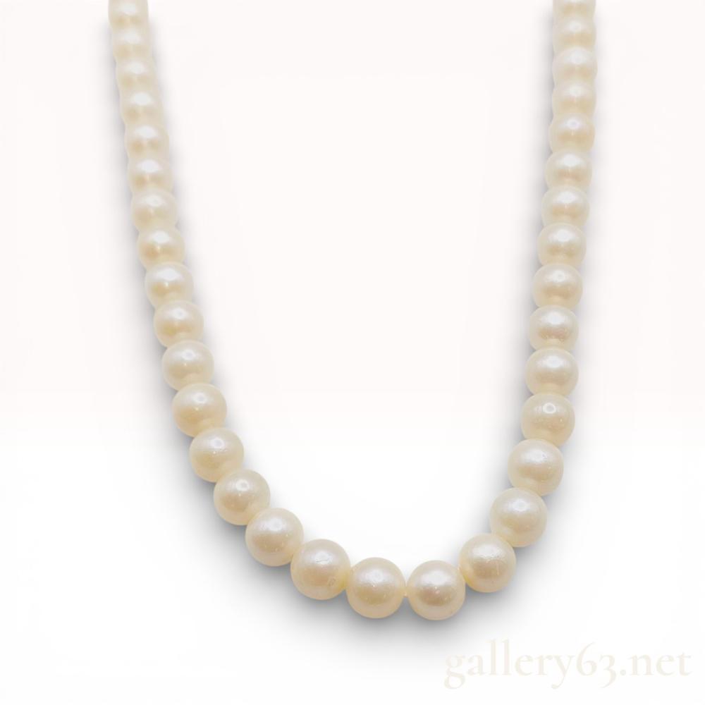 Description
Cultured pearl necklace, mid-20th century. Single strand of white to cream-colored pearls measuring approximately 6.5mm to 7mm, individually knotted on white thread. Features an oval filigree box clasp with a safety tongue, stamped SILVER in capital block letters on the reverse.
Length: Approximately 15.5 inches.