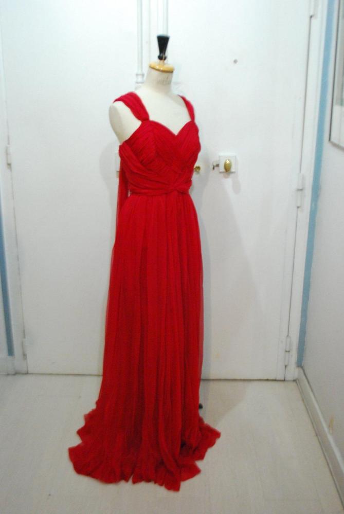 Jean DESSES, haute couture, circa 1950

Robe longue en mousseline rouge, haut drapé se croisant, à poitrine découpée sur larges bretelles se finissant par panneaux volants, jupe fluide avec effet de surjupe large à taille haute. Griffe noire, graphisme blanc