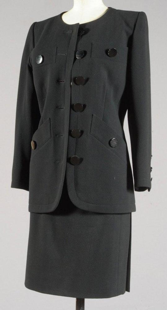 Yves SAINT LAURENT

Haute couture n° 62437 circa 1993/1995 Veste en ottoman noir, ras du cou, simple boutonnage, deux poches poitrines en biais, deux revers et deux poches également en biais, la veste est doublée de satin fuchsia de même couleur que la jupe droite en gabardine de laine. Griffe blanche, graphisme noir