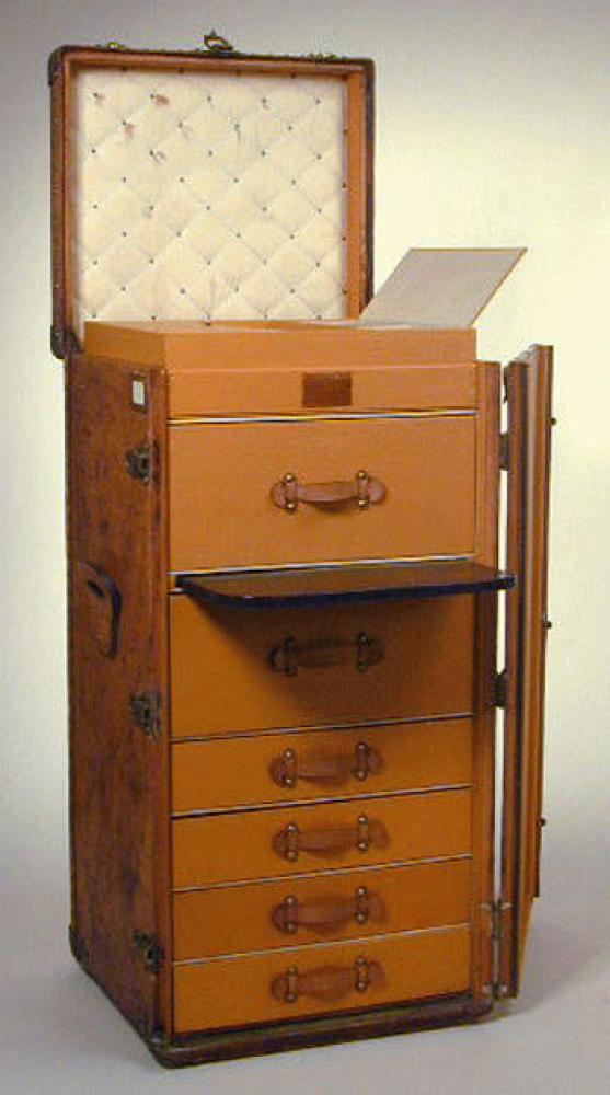 Louis Vuitton Custom Leather Wardrobe Trunk

Lot 1245
Louis Vuitton Custom Leather Wardrobe Trunk
 1930s 
 Tan leather, with brass fittings, flat leather side handles, with top and side openings, the interior fitted with six drawers with leather handles, a pull-out desk top, compartments for jewelry and other small items at top, lock no. 063413, and lock and interior paper label marked: Louis Vuitton, interior no. 779913. Height 44 inches, width 22 inches, depth 20 inches.
Very good condition, exterior shows use, leather trim damage, interior pristine, except some marks on quilted top lining.