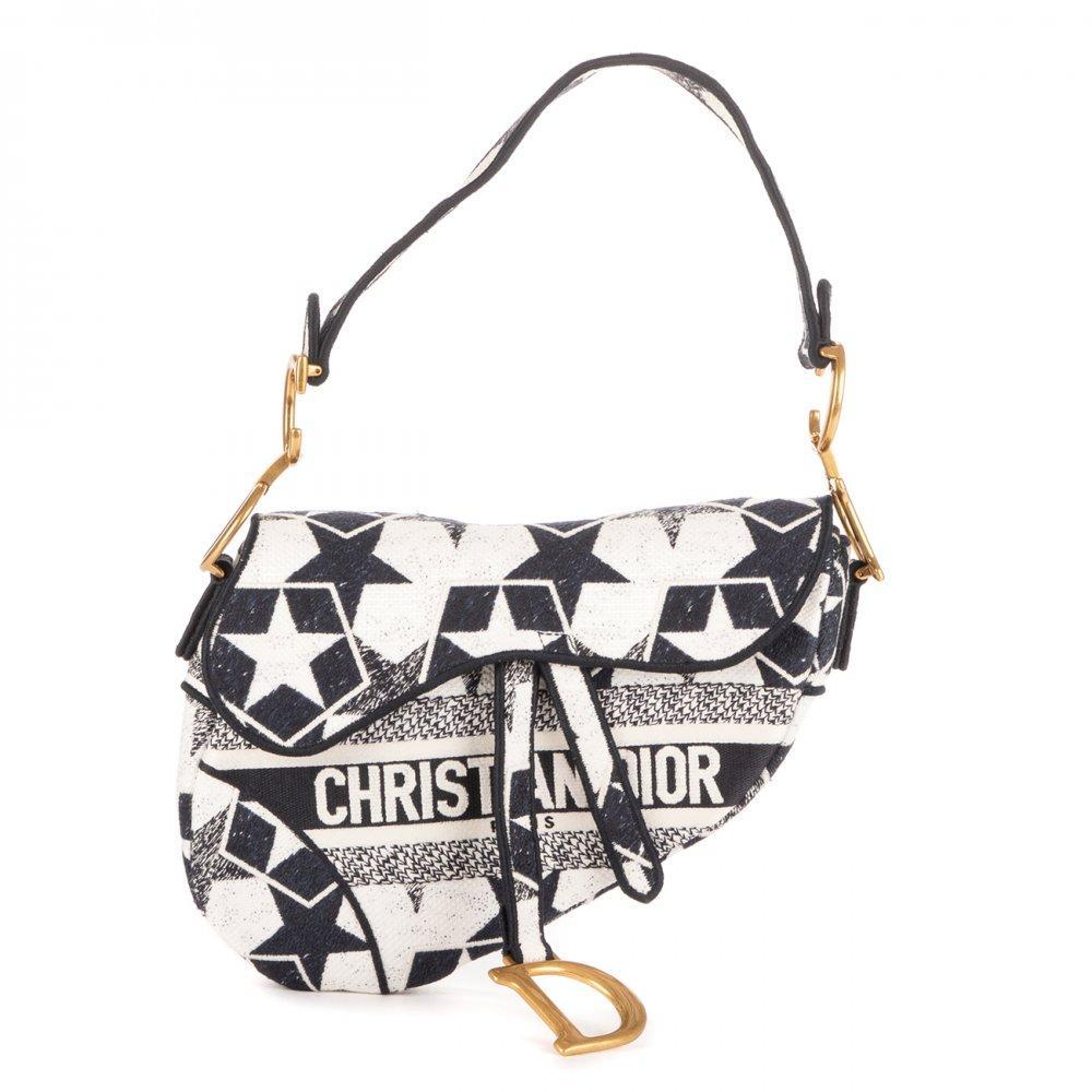 Description

DIOR Stars Embroidered Saddle Bag.
Crafted in embroidered canvas with stars motif in navy blue and white, on an ecru or ivory background. Features iconic saddle silhouette with asymmetrical flap and hidden magnetic closure. Hanging metal "D" detail on the bottom of the flap and "CD" lettering on the side rings of the short leather handle. Lined interior with main compartment and zippered pocket. Handle to carry on the shoulder or in the hand.
In perfect condition, barely unused.
Measurements: 23 x 20 x 4 cm.

This model is part of one of the most celebrated special editions of the DIOR Saddle Bag, where the house reinterprets its iconic design -created by John Galliano in 1999- with embroideries of celestial inspiration, evoking elements of the mystical universe that Dior has explored since its origins. The navy blue and white composition, along with the embroidered stars, brings a romantic and ethereal air, fusing artisanal savoir-faire with strong visual identity. Considered a collector’s item, this Saddle is highly sought after for its limited edition and highly detailed execution.

Since its relaunch under the direction of Maria Grazia Chiuri, the Saddle Bag has reaffirmed itself as one of the maison’s contemporary icons, a symbol of bold style and reinvented heritage.