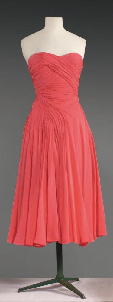 Emilio SCHUBERT Roma, circa 1950

Robe de cocktail en mousseline coq de roche, haut bustier drapé en assymétie redescendant sur la taille et les petites hanches pour finir dans l’ampleur de la jupe travaillée en biais, dos à l’identique. Griffe blanche, graphisme noir