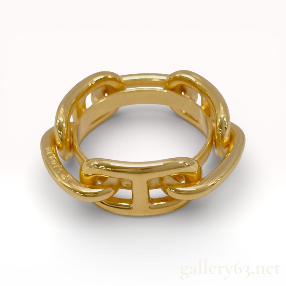 Description
Hermès scarf ring having a polished gold-tone metal construction. Circular form featuring interlocking chain-link style segments with openwork detailing throughout. Design presenting a smooth, high-gloss finish suitable for securing and styling silk scarves. Piece showing solid weight and sculptural proportions consistent with Hermès accessory design.