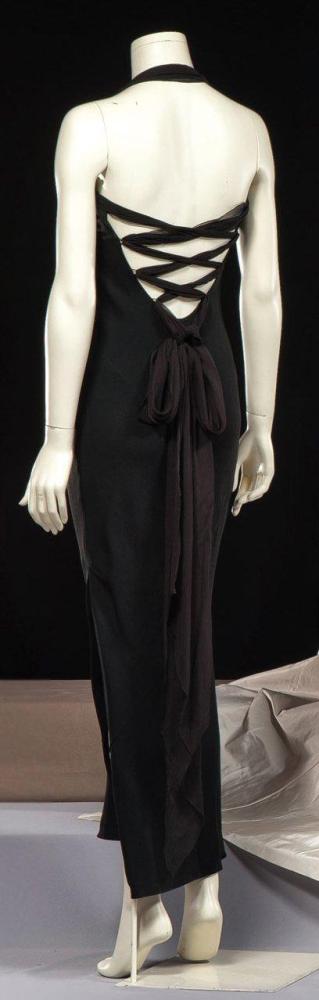 Christian DIOR

Boutique par John Galliano Robe du soir longue en crêpe noir, haut bustier sur dos nu à effet de laçage par de la mousseline à la couleur finissant en pans, côté gauche à boutonnage bride, jupe fendu