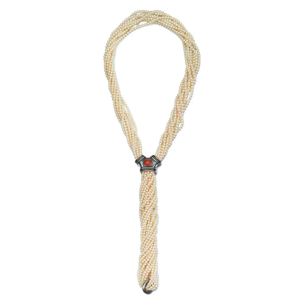 René Boivin

Composed of eight rows of cultured pearls gathered in a slide set with a carnelian cabochon.

-Formerly in the collection of Carmen Saint

By descent to the current owners

-Private collection, Paris

Carmen Saint (Rio, 1917 – Paris, 2016), a Brazilian socialite who settled in Paris in 1943. She married Jorge Lage, then Daniel Saint. A friend of Hélène Rochas, Jacqueline Delubac, and Zozo de Ravenel, she was photographed by André Ostier, notably at the famous Bal des têtes. She is the mother of Betty Catroux.