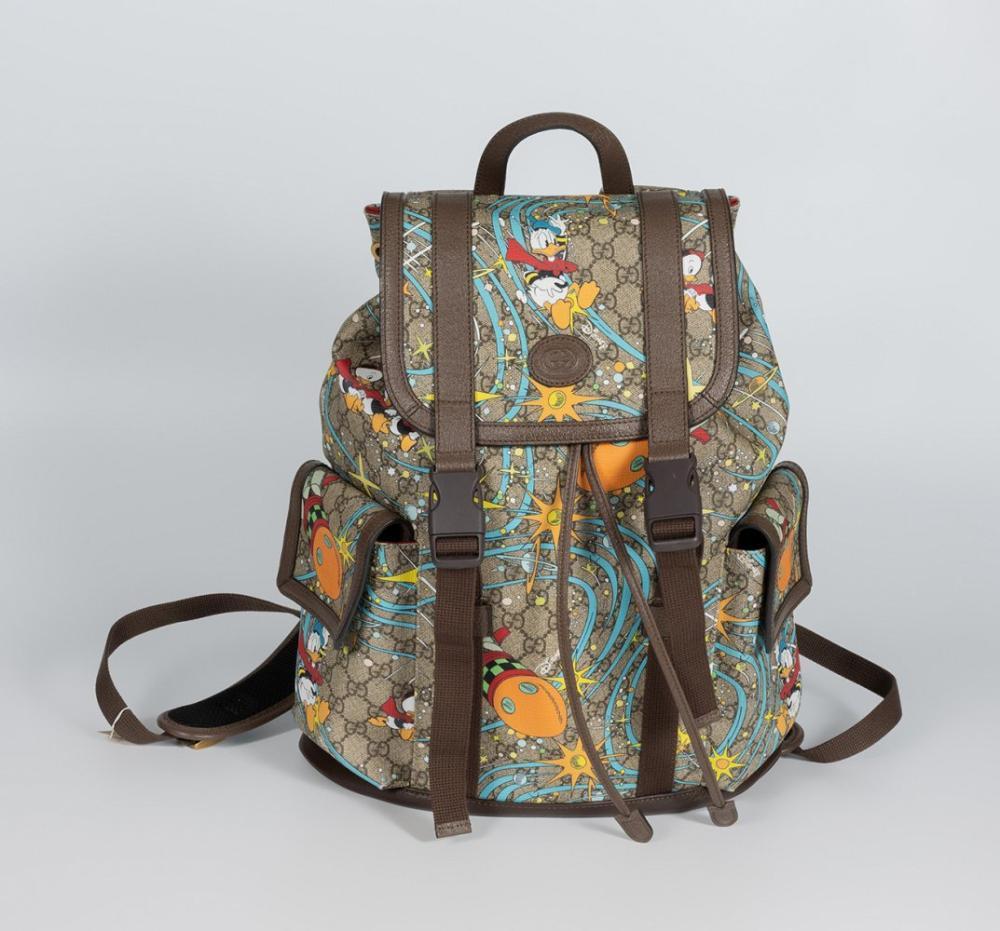 Description

GUCCI X Disney.
Donald Duck backpack.
In GG Supreme canvas with Donald Duck print. Brown leather details. Features two exterior pockets. Flap closure with two exterior buckles. Inside pocket lined in red fabric.
In good condition, with very light marks of use.
Measurements: 35 x 40 x 11 cm.

Launched around 2020 under the creative direction of Alessandro Michele, this collection celebrated the Chinese New Year and the Year of the Mouse, incorporating iconic characters from the Disney universe into the brand’s classic codes.
The backpack stands out for integrating the figure of Donald Duck on the emblematic GG Supreme canvas, one of Gucci’s hallmarks, thus combining tradition and a playful visual language. This contrast between the rigor of the monogrammed pattern and the spontaneity of the character introduces an ironic and contemporary aesthetic, characteristic of the brand’s creative approach at this stage.

In good condition, with very light marks of use.