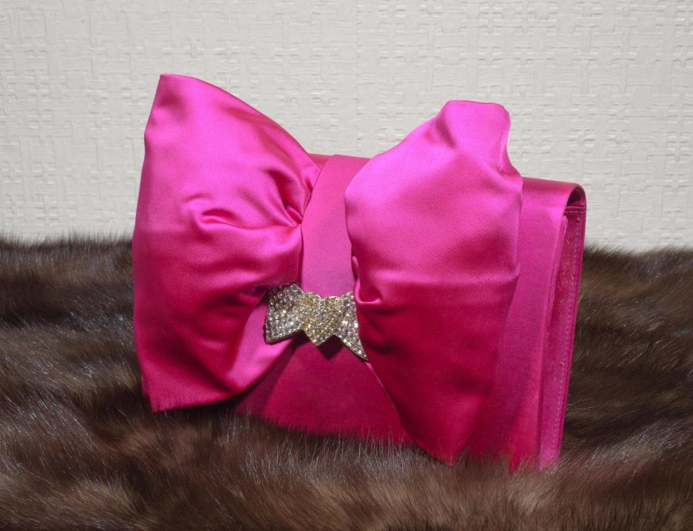 Diamant noirSac du soir en satin fuchsia…

Diamant noirSac du soir en satin fuchsia orné d’un important noeud rehaussé d’un motif serti de strass, fermoir aimanté.