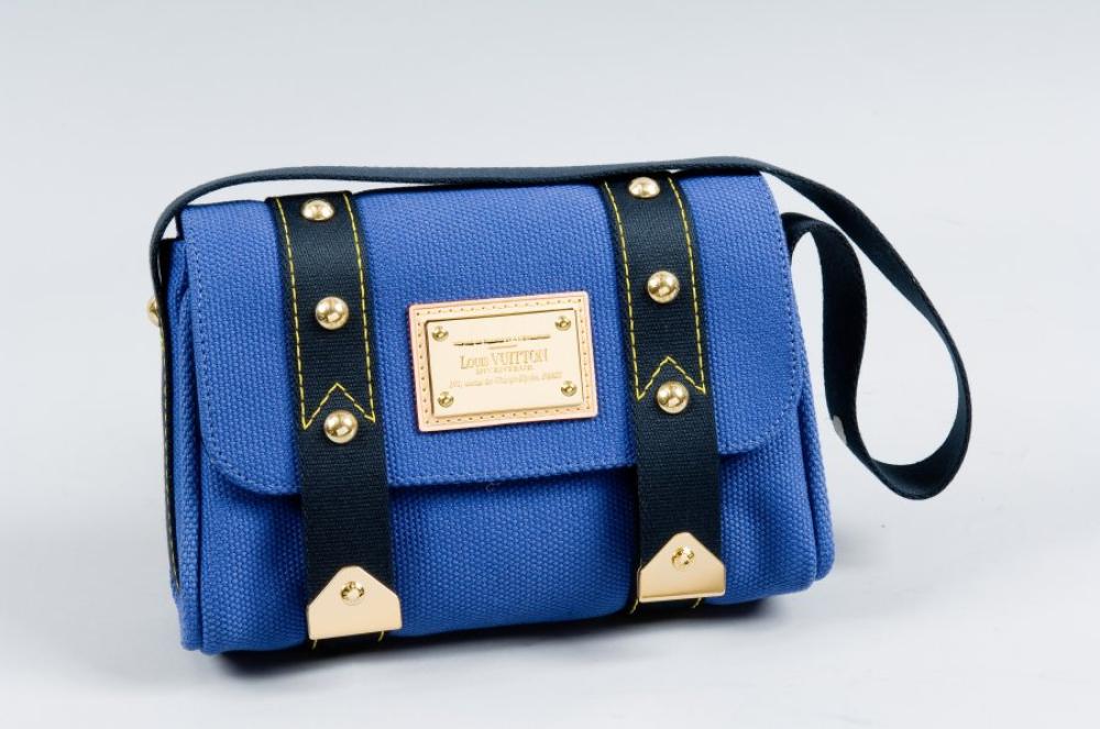 Louis VUITTON

Sac "rabat" en toile antigua bleu, fermetures aimantées sous rabat agrémenté d’une plaque en laiton doré montée sur cuir naturel "Louis VUITTON  inventeur 101, avenue des Champs Elysées, Paris", anse sangle bandoulière marine surpiquée jaune, rappel sur le sac. Très bon état