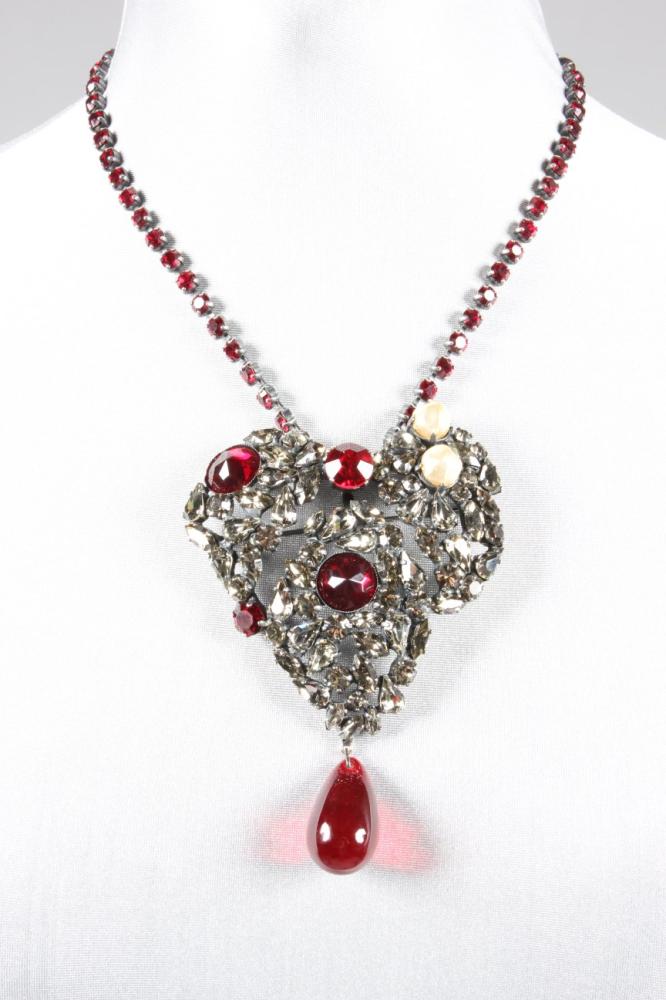 

An Yves Saint Laurent heart-pendant necklace/brooch, Autumn-Winter, 1996-7, signed to the reverse, of smoke-grey tinted and red brilliant cut stones, baroque pearl beads, with cabochon droplet, brooch pin to the reverse, the white metal chain inset with red stones,i  the chain 44cm long
