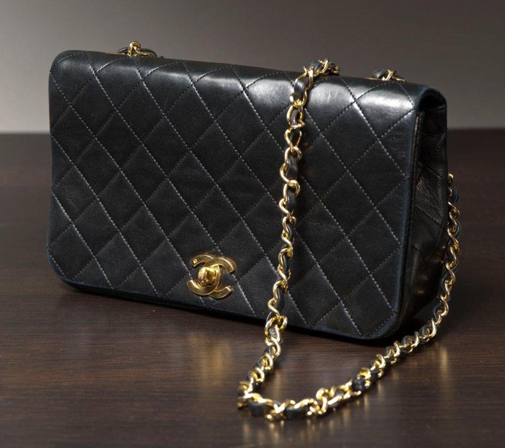 CHANEL

Sac en cuir agneau matelassé noir, fermeture siglée en métal doré sur rabat, anse bandoulière chaine en métal doré entrelacée de cuir. long: 23 cm. Bon état