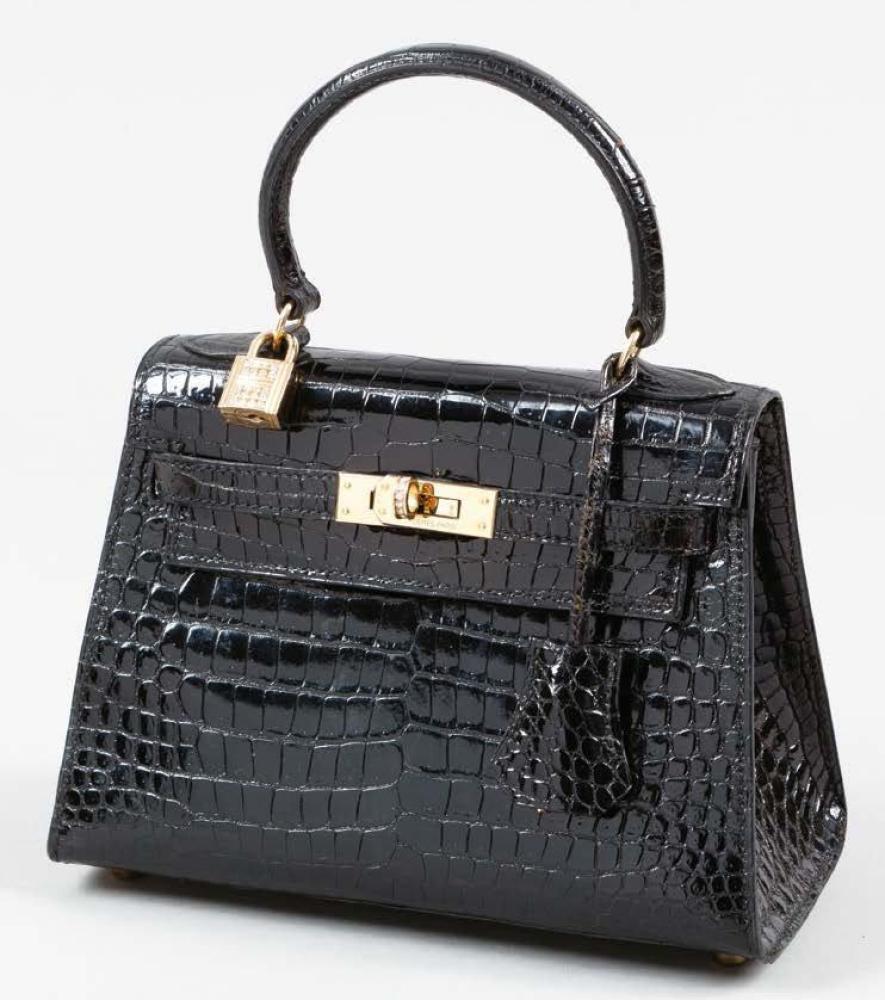 HERMES Paris made in France

Mini sac "Kelly" 20cm en crocodile porosus noir, attaches et fermoir plaqué or, pivot et cadenas sertis de brillants, poignée, clefs. Très bon état (très légères usures aux coins). Ce lot a été confectionné dans des parties d’espèces de crocodylidaes spp classées aux Annexes II/B de la convention de Washington et de la Règle 338/97 du CE 9/12/1996). Pour une sortie de l’UE un CITES d’export sera nécessaire celui-ci étant à la charge du futur acquéreur.