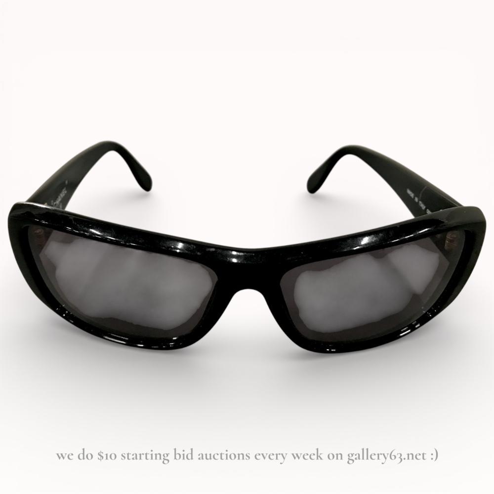 Description
Authentic Chanel black wrap-style sunglasses featuring a glossy molded frame and dark tinted lenses. Curved rectangular lenses set within a continuous sculpted front. Tapered arms extending to hooked temple ends. Chanel branding present at the temples. Contemporary shield-inspired silhouette with a streamlined, high-polish finish.