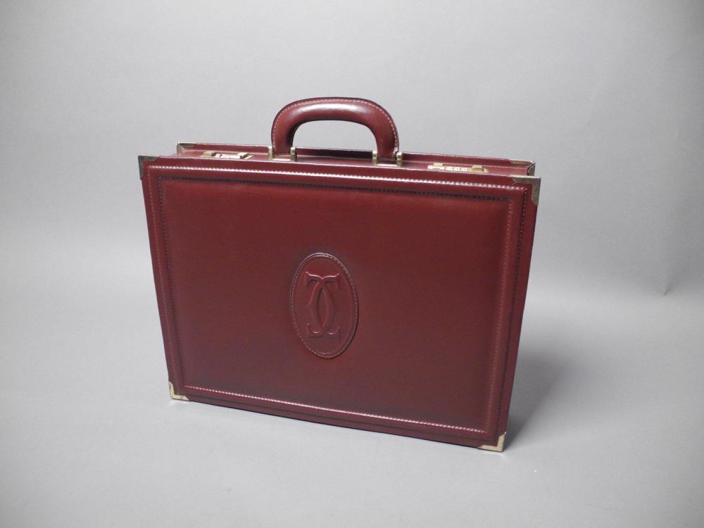 CARTIER

Bel attaché-case en cuir bordeaux siglé Coins renforcés et fermetures à codes secrets en métal doré Intérieur en tissu rouge avec de nombreux compartiments Dim : 44 x 33 x 9 cm EN TRES BON ETAT