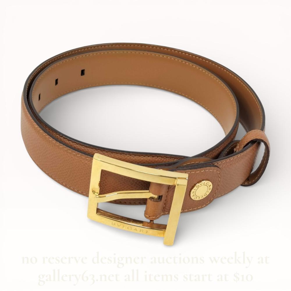 Description
Bulgari designer belt, contemporary. Features a tan pebble-grain leather exterior, smooth leather interior, gold-tone rectangular buckle, and branded circular stud. Interior is heat-stamped BVLGARI, MADE IN ITALY, and LOMTEE; buckle and stud also bear brand markings.
Total Length: Approximately 36 inches (92 cm)
Width: Approximately 1 inch (2.5 cm).