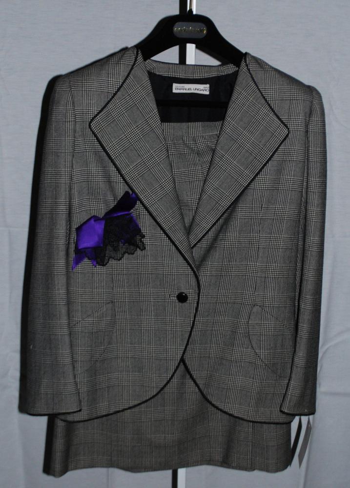 Emanuel UNGARO Couture n° 5855.31.3.80 circa 1980

Tailleur en Prince de Galles noir et blanc gansé de soie noir, demi col châle, deux poches en biais à rabat arrondis, boutnnage à un bouton, manches longues, jupe droite