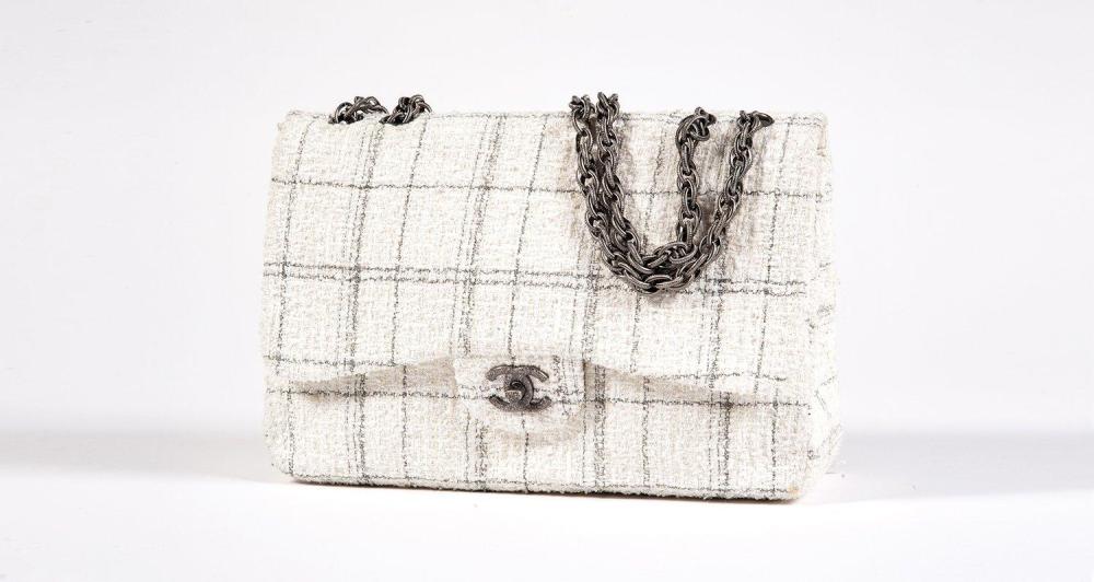 CHANEL

Magnifique sac "Jumbo" 30cm en tweed bouclette écru figurant des carreaux par une ligne gris foncée, effet de brillance par des paillettes et un fil de soie polyester, fermoir siglé en acier chromé gravé sur rabat, anse chaîne à maillon fantaisie à finition perlée à l’identique. Excellent état