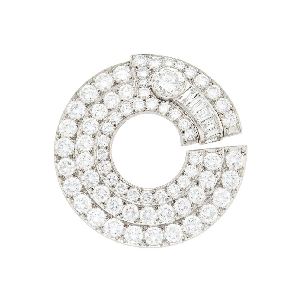 From the Family of a New York DiplomatOne round diamond ap. 1.95 cts., 35 round diamonds ap. 12.60 cts., 32 round and transitional-cut and 6 baguette diamonds ap. 5.50 cts., circa 1935, ap. 21.3 dwts.

Large diamond: G-H-I-VS, grading in so far as mounting permits.Diamonds: G-H-I-VS,Well-made. Diameter 2 inches.                            
Any condition statement is given as a courtesy to a client, is an opinion and should not be treated as a statement of fact and our Organization shall have no responsibility for any error or omission. Please contact the specialist department to request further information or additional images that may be available.