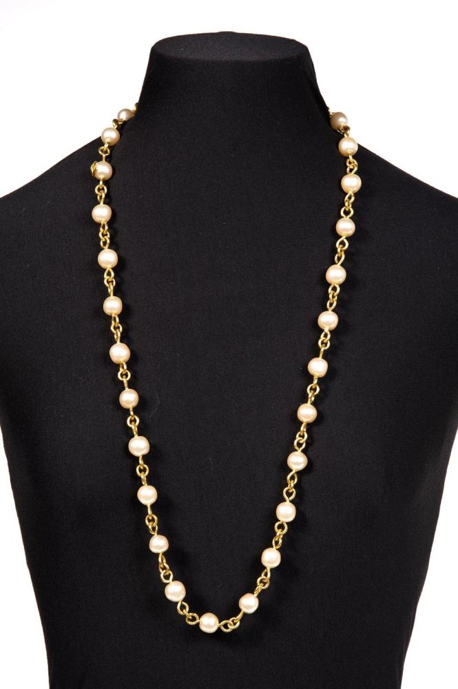 CHANEL

Sautoir en métal doré retenant des perles à l’imitaion perles de culture. Bon état (manque un perle au fermoir). Signé