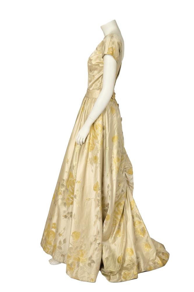 A James Galanos Originals ballgown, circa 1960

A James Galanos Originals ballgown, circa 1960

labelled, the ivory satin woven with large-scale silver and yellow roses, with curved seams to bust which follow the curve of the front high neckline, scooped low back, the rear skirt gathered into a buttoned placket band, bust approx 86-92cm 24-36in, waist 71cm 28in

Share this lot: