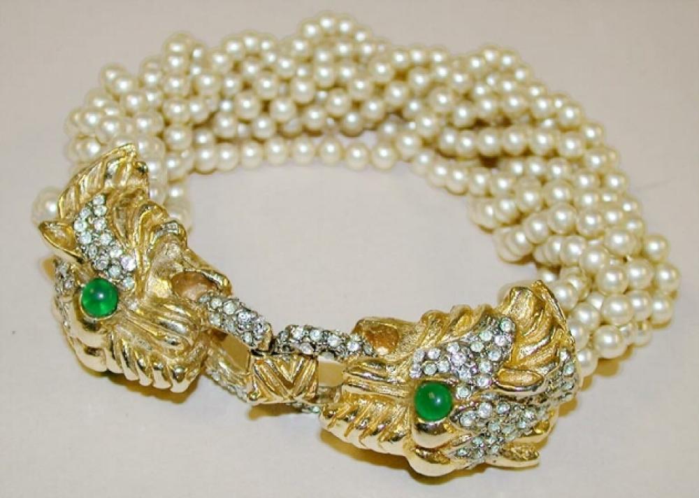 Kenneth Jay Lane Pearl Bead Bracelet

Lot 913
Kenneth Jay Lane Pearl Bead Bracelet
 American, circa 1965. 
 Twisted strands of pearl beads with gilt-metal panther’s head clasps encrusted with diamante and emerald colored eyes, marked: KJL.