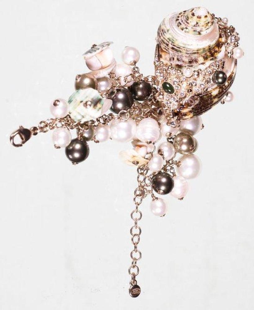 CHANEL CIRCA 2007

Bracelet composé d’un escargot orné de strass et de perles retenues par des chaînes en métal argenté agrémenté de breloques de perles. Signé, daté