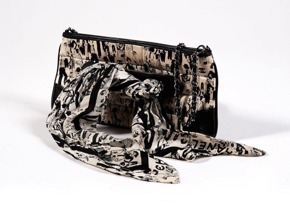 CHANEL

Sac baguette 28cm en soie matelassée ivoire imprimée noire représentant l’effigie de Mademoiselle Chanel, bords et coins en cuir noir, fermeture éclair, anse chaîne bandoulière en métal vieilli entrelacée de cuir, devant orné d’un carré en soie imprimée à l’identique, retenu par une poignée en cuir amovible ajourée de deux oeillets. Très bon état