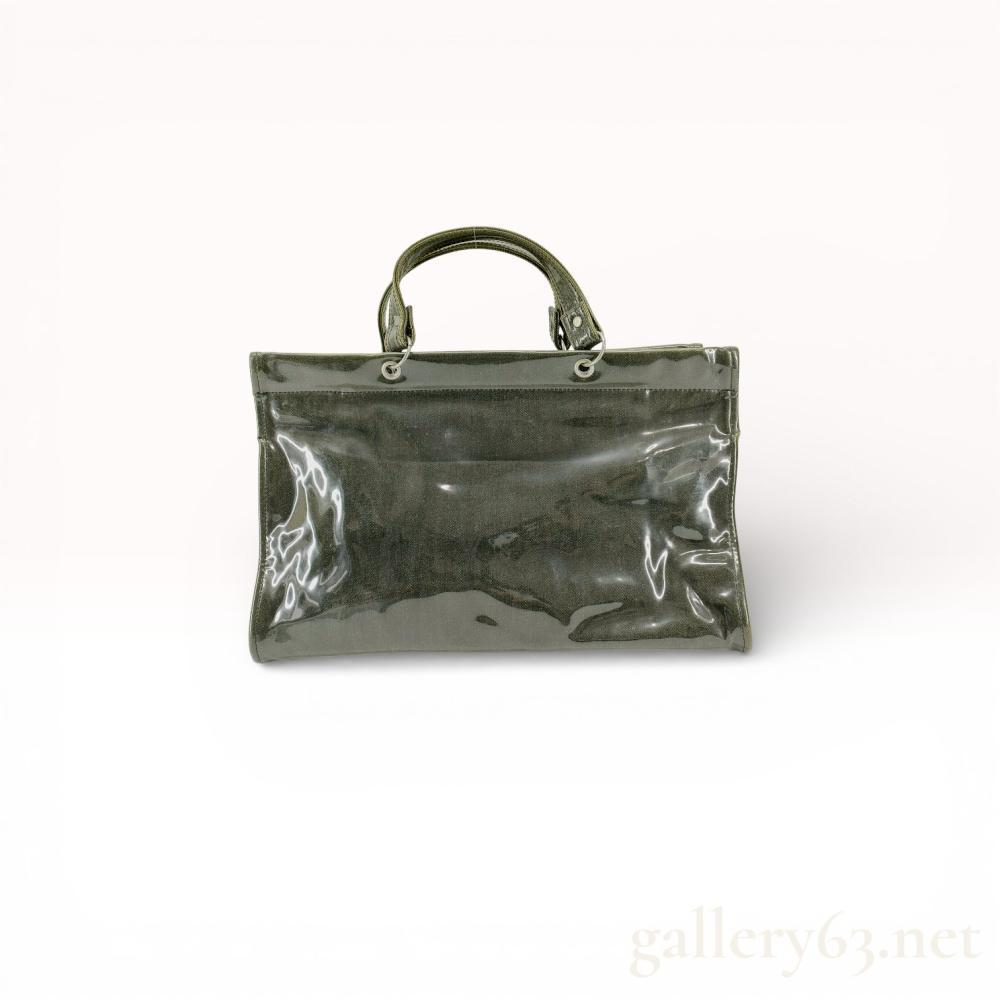 Description
tricot Comme des Garcons top-handle tote bag. The design features a dark gray denim body encased in a transparent PVC outer layer with silver-tone hardware and five protective metal feet. The interior is lined with a light-colored twill fabric and contains multiple zippered pockets and a woven brand label.
Width: 14.5 inches
Height: 9.5 inches
Depth: 4.5 inches.