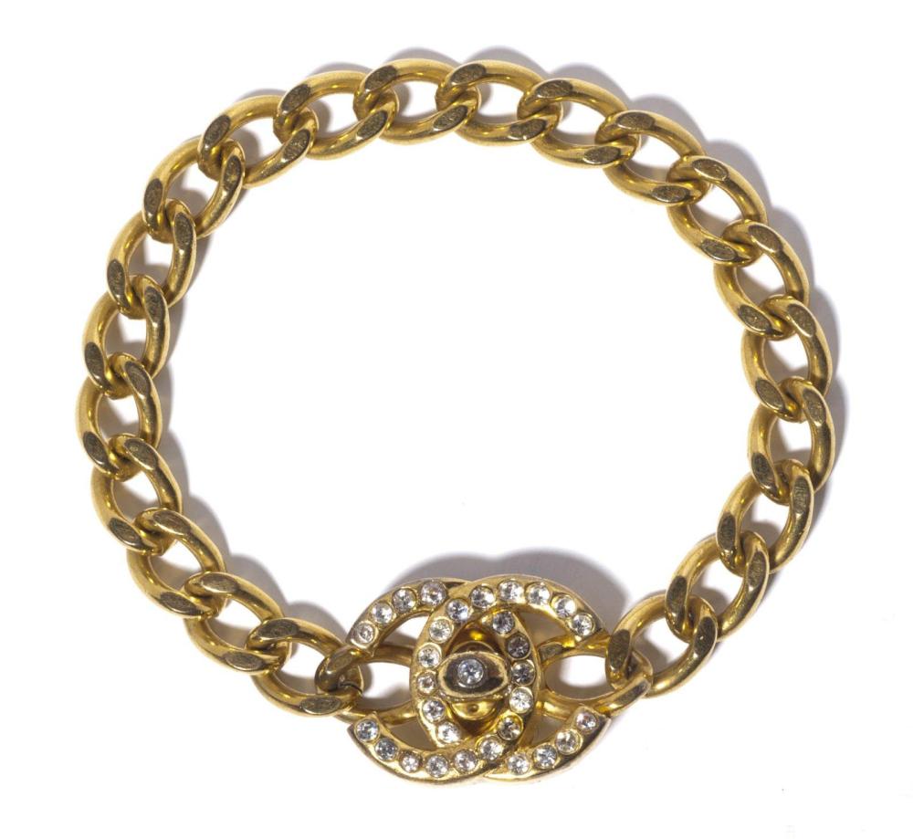 CHANEL

Tour de cou chaîne torsadée en métal doré retenant un sigle serti de strass à l’imitation brillant. Signé