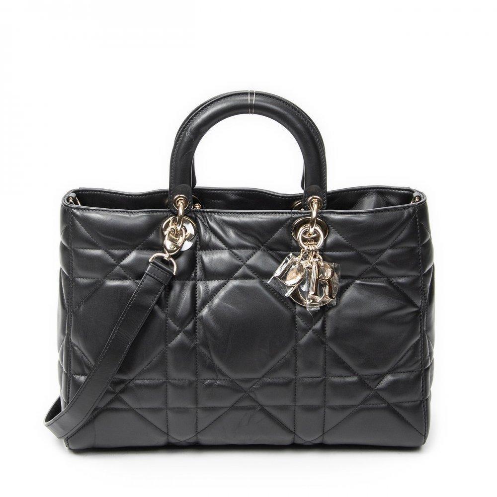 Description

DIOR
Large Lady D-Sire bag.
In black Macrocannage calfskin leather. Features double leather top handle and removable long leather shoulder strap in the same color. Gold-tone hardware and zipper closure.
Includes long handle, leaflet and charm.
With interior numbering.
In excellent condition, slight signs of use.
Measurements: 35 x 23 x 15 cm.
The conceptual origin of the Lady D-Sire comes directly from the legacy of the Lady Dior, an emblematic bag introduced in 1995 and associated with the timeless elegance of the maison. In this reinterpretation, Dior maintains the fundamental codes, such as the "D.I.O.R." charms and artisanal expertise, but transforms its structure to meet new aesthetic and functional needs.
Unlike the traditional Lady Dior, known for its rigid and architectural shape, the Lady D-Sire is characterized by a more flexible and relaxed silhouette. This change is not accidental: it responds to a more urban vision of luxury, where comfort and naturalness are so important.

Includes long handle, brochure and charm. With interior numbering. In excellent condition, light signs of use.