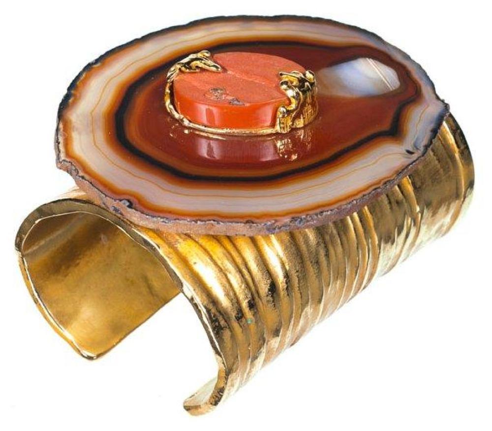 YVES SAINT LAURENT CIRCA 2000

Bracelet manchette ouvert en métal doré gravé d’inspiration esclave orné d’une importante plaque en agate brune rehaussée d’une pierre dure sertie de métal doré. Signé