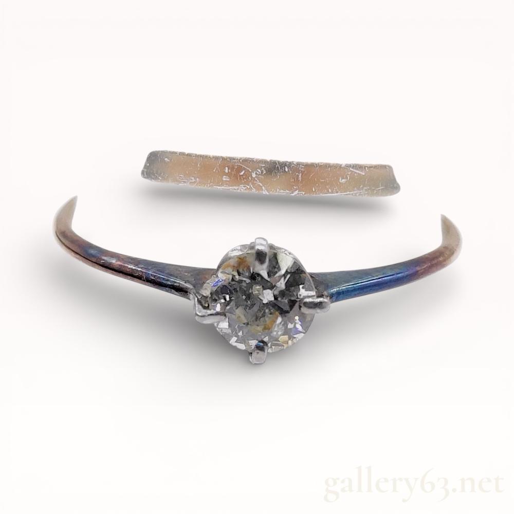 Description
Estate solitaire engagement ring featuring a round brilliant-cut salt and pepper diamond. The center stone is secured in a four-prong white metal head integrated into a tapered 18 karat yellow gold shank. The interior of the band contains a K18 gold purity stamp and a K.H maker mark alongside faint illegible characters.
Ring size: US 11.