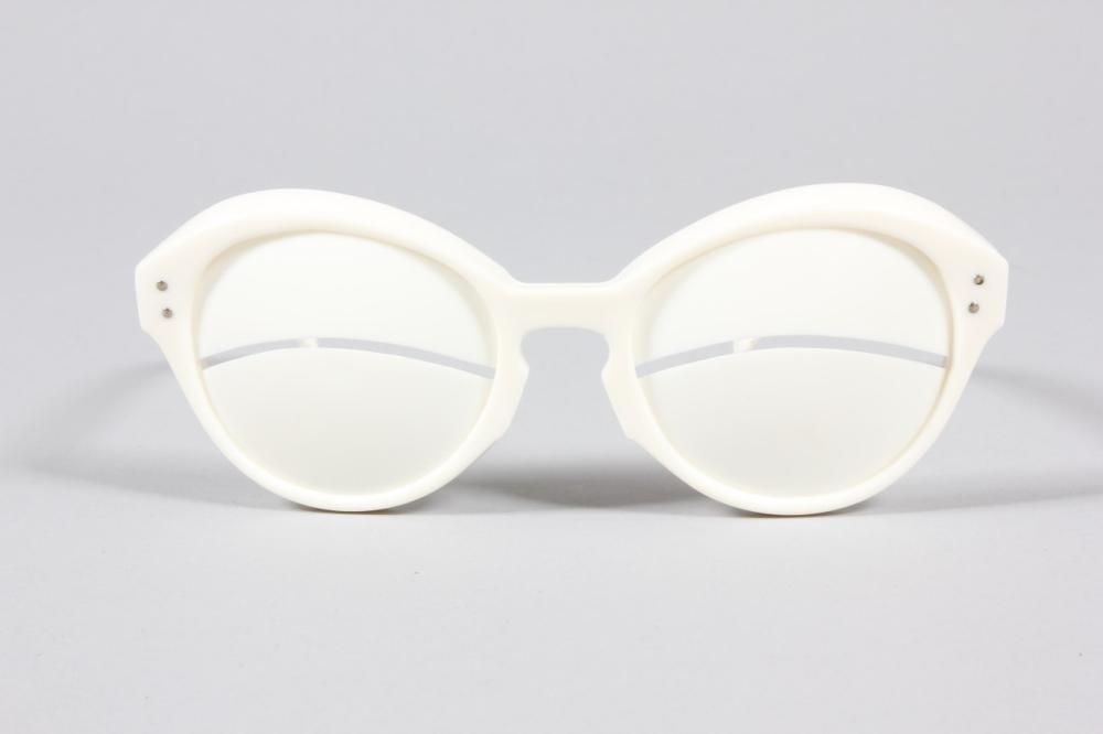 

A pair of Courrèges white plastic sunglasses, 1964, signed along the arms, the solid lenses with horizontal slits, i 15cm, 6in long
