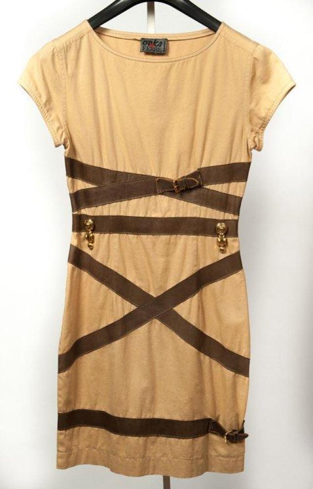 Gianfranco FERRE

Robe en toile beige ornée de ceintures de cuir marron enserrant la robe à partir de la taille, encolure bateau, petite manches.