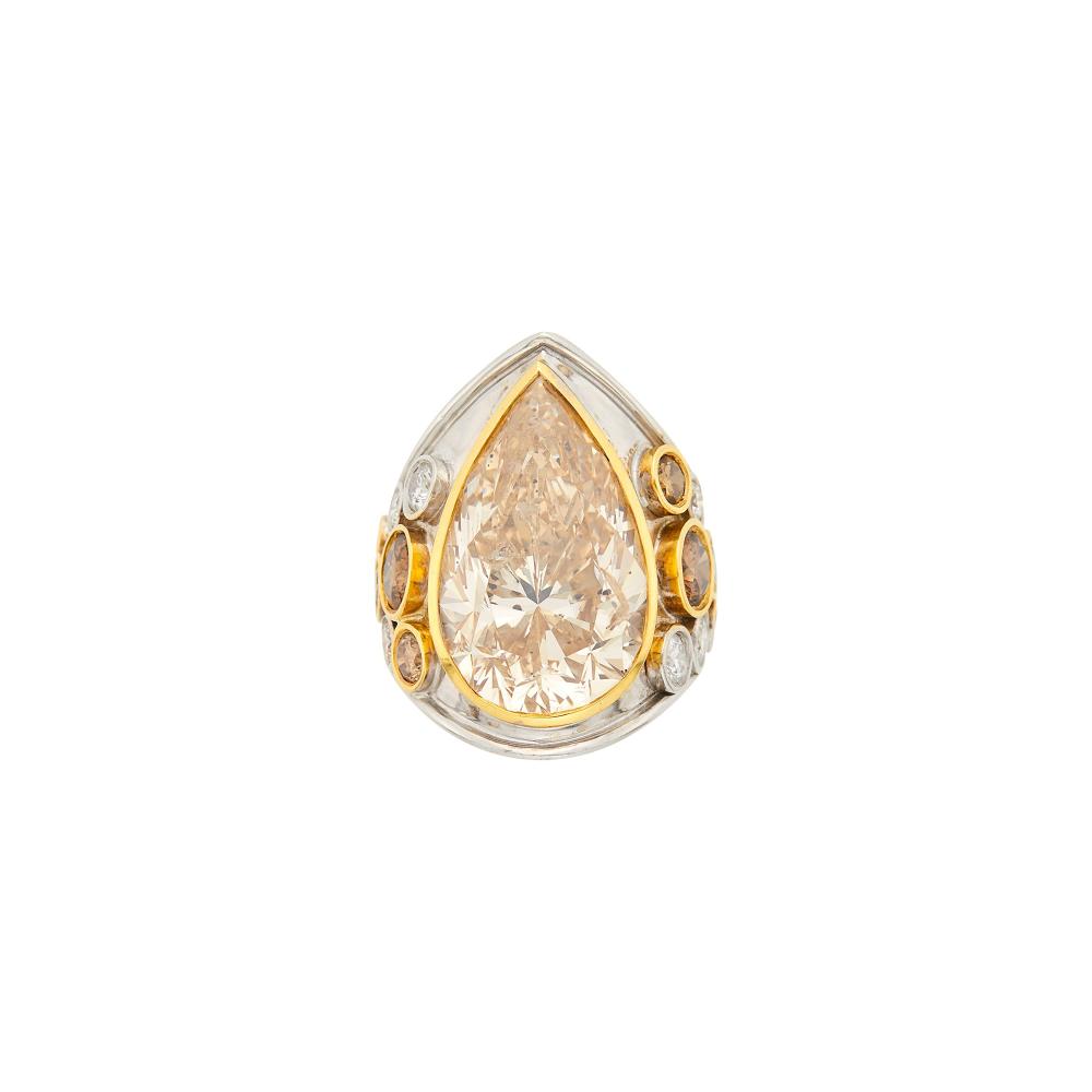 Property from a Prominent Private Collection18 kt. yellow and white gold, one pear-shaped brown diamond ap. 20.75 cts., 8 round orangy brown diamonds ap. 2.00 cts., 10 round diamonds ap. 1.15 cts., ap. 18.6 dwts. Size 6.

The colored diamonds have not been tested.

Center diamond: medium light orangy-brown, I1, strong blue fluorescence, two large feathers near edge of table and black inclusions at crown facets and at edges of table facet, nice shape and cut, brilliant.Colored diamonds: medium orangy brown to deep orangy brown, VS-SI.Diamonds: G-H-I-VS.Width 1 3/16 inches.                            
Any condition statement is given as a courtesy to a client, is an opinion and should not be treated as a statement of fact and our Organization shall have no responsibility for any error or omission. Please contact the specialist department to request further information or additional images that may be available.