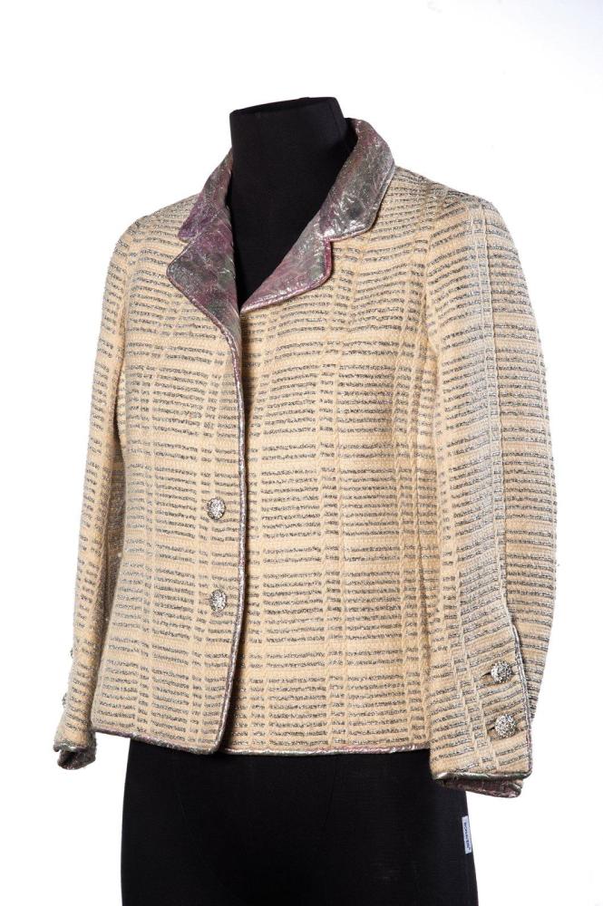 CHANEL

HAUTE COUTURE CIRCA 1968 Tailleur en lainage écru et lamé argent doublé de broché rose, argent, veste à col tailleur laissant apparaître la doublure, simple boutonnage strassé, manches longues. Sans Griffe. (transformation à la jupe)