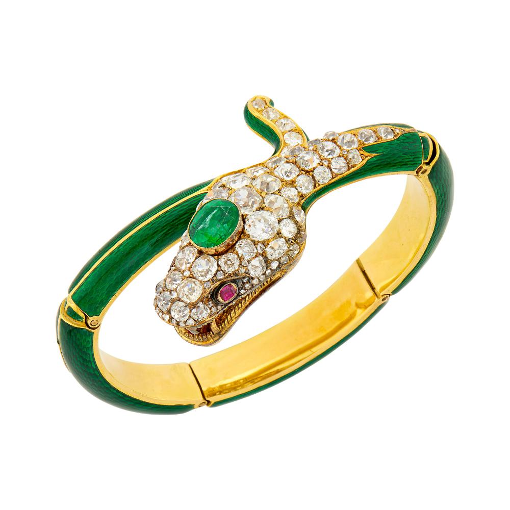 Property of a Prominent CollectorPatterned green enamel, one oval emerald ap. 8.6 x 7.3 mm., 50 cushion-shaped and old mine-cut diamonds ap. 7.00 cts., rose-cut diamonds, cushion-shaped ruby eyes, one free-form ruby in mouth, circa 1845, ap. 27 dwts. Inner circle 6 1/8 inches, adjustable.

Tests for 18 kt.Emerald: medium green, included, some visible, minor abrasions at crown facet junctions.Diamonds: H-I-J-VS-SI, lumpy cuts.Rubies: medium deep raspberry, ruby tongue chipped, minor abrasions and chips at crown facets.Width 1 to 5/16 inch.                            
Any condition statement is given as a courtesy to a client, is an opinion and should not be treated as a statement of fact and our Organization shall have no responsibility for any error or omission. Please contact the specialist department to request further information or additional images that may be available.