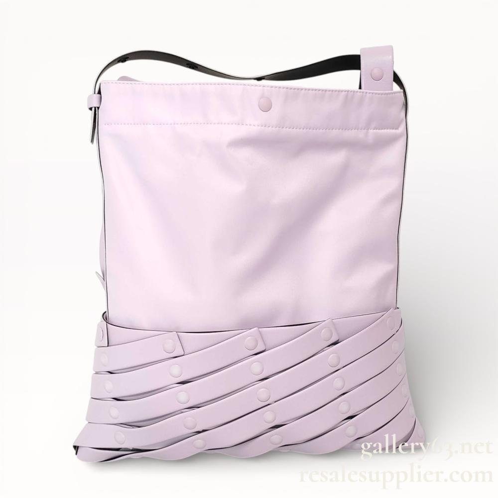 Description
Issey Miyake Spiral Grid shoulder bag, contemporary. The upper body is constructed from lilac technical synthetic fabric, while the lower section features an architectural lattice of tonal straps secured by snap-button fasteners. Features include a wide adjustable shoulder strap, light gray chevron-patterned textile lining, and an interior slip pocket with an embossed ISSEY MIYAKE label.
Width: 14.5 inches (37 cm)
Height: 16.5 inches (42 cm).