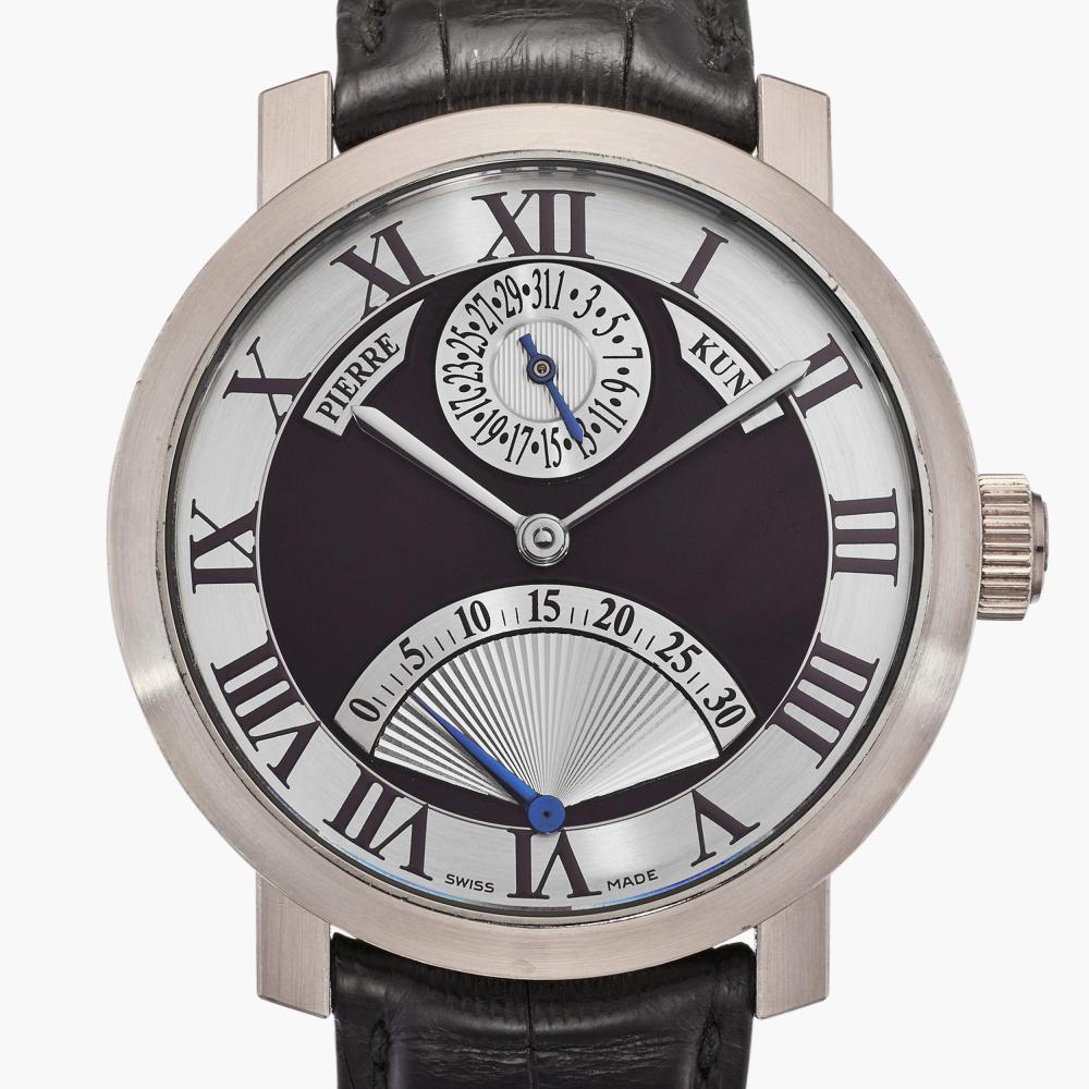 Pierre Kunz

Dial: silvered, matte black center field

Caliber: cal. ETA 2892-A2 automatic, 21 jewels

Case: 18k white gold, case back secured by six screws

Case number: 03

Closure: 18k white gold Pierre Kunz buckle

Size: 41 mm diameter

Signed: case, dial and movement

Box: no

Papers: no

Pierre Kunz began his career within the Franck Muller Group, where his creativity and technical ingenuity quickly distinguished him. His ideas and designs were so well received that Franck Muller and Vartan Sirmakes encouraged him to establish his own brand within the Group, allowing him to further develop his distinctive horological vision.

The present example highlights one of Kunz’s signature complications: the retrograde display. Housed in an elegant white gold case, the two-tone dial features a retrograde seconds indication that advances in a sweeping arc before jumping crisply back to zero every thirty seconds. This dynamic display exemplifies Kunz’s flair for combining mechanical sophistication with visual animation.

Sporty yet refined, the watch achieves a harmonious balance between technical ingenuity and sleek design, making it both an engaging complication and a versatile wrist companion.